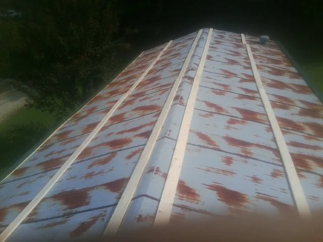 Rusted metal roof panels with new wood purlins before replacement — Storm Damage Roof Repair in Avenue by Roofing Brothers