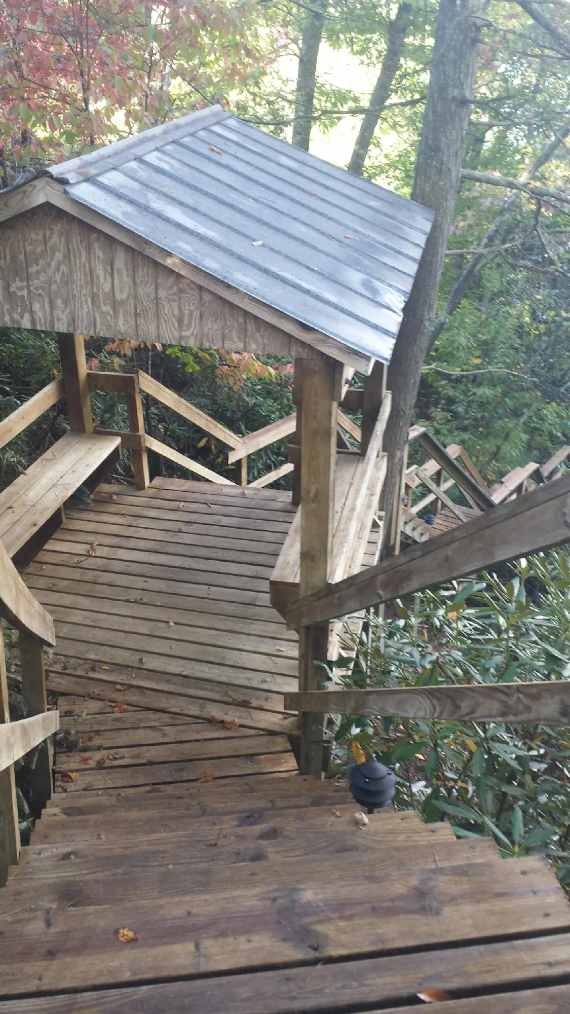 Metal roofed shelter over wooden steps on a wooded walkway — Skylight Repair & Installation work by our crew in Avenue