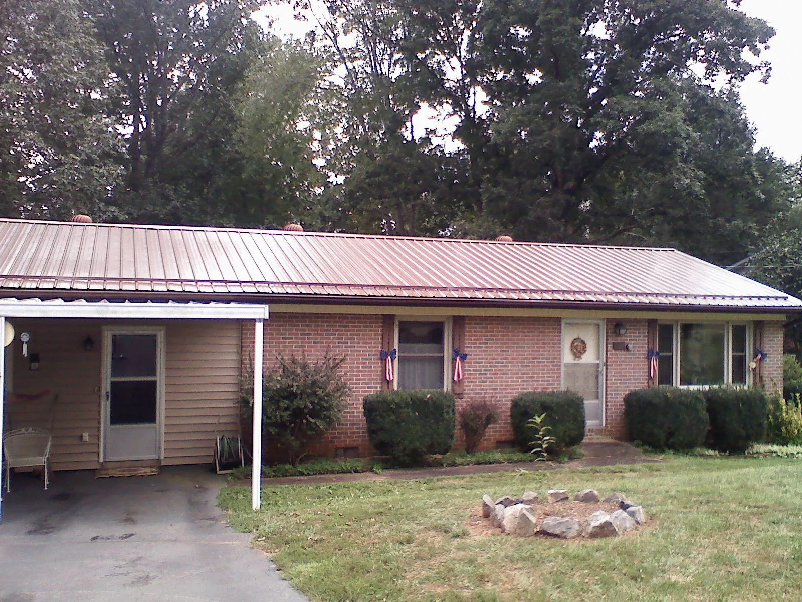 Bronze metal roof and carport on a brick ranch home — Roof Repair work by our crew in Avenue